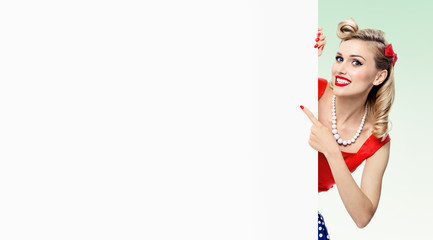 woman in pin-up style dress, showing blank signboard