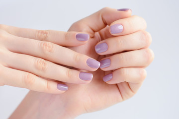 Fototapeta premium Closeup of hands of a young woman with pink manicure on nails