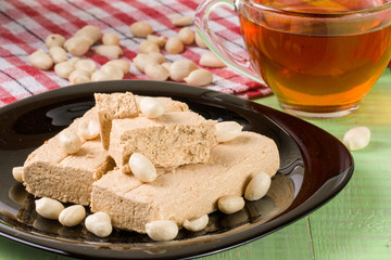 peanut halva in the plate on a green wooden background