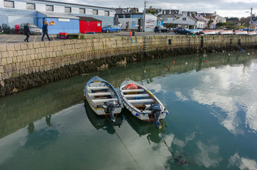 Fototapeta na wymiar Fishing boats reflected in water and utility buildings on the shore in Dublin fishing harbor