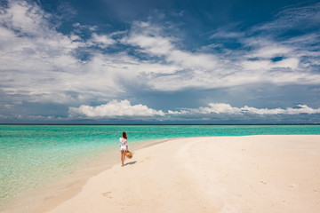 Woman with sun hat on tropical beach