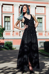 Fototapeta premium Fashion portrait of gorgeous girl with blue dyed hair long. The beautiful evening cocktail dress.