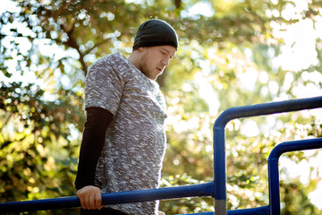 Naklejka premium Healthy handsome active man with fit muscular body doing workout exercises. Outdoor, park. Sports and fitness concept