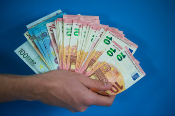 Geldschein in der Hand, blauer Hintergrund