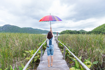 Woman holding an umbrella on the bridge.