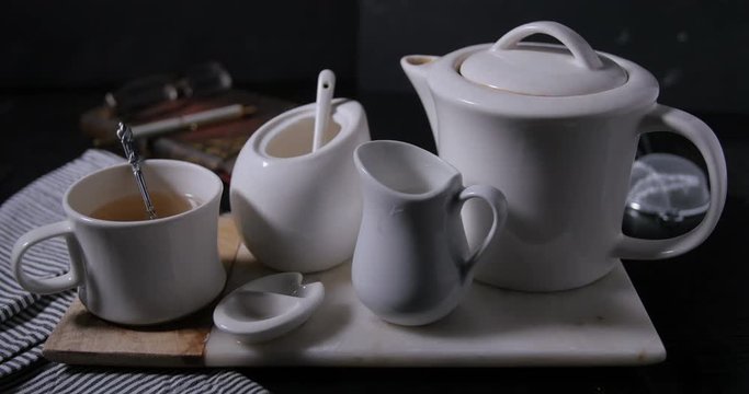 Adding milk to a nice steaming hot cup of tea from the tea pot