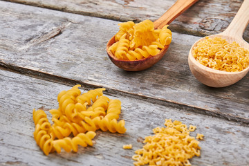 Two types of Italian pasta in wooden spoons.