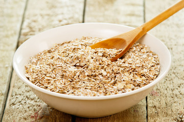 Uncooked oatmeal and wooden spoon