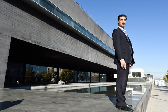 Young Businessman Wearing Blue Suit And Tie In Urban Background