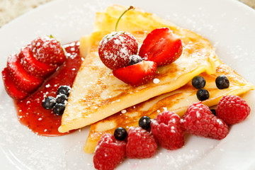 Pancakes with berries and sugar powder