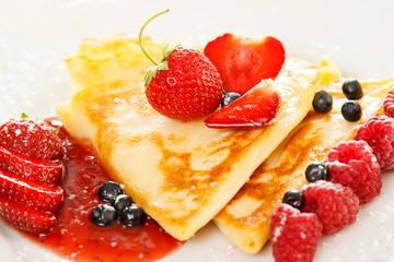 Pancakes with berries and sugar powder
