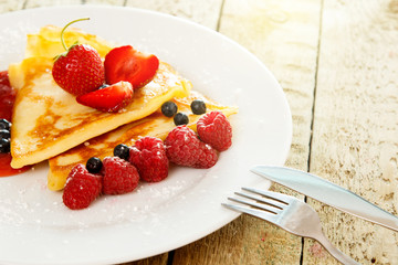 Pancakes with berries and sugar powder