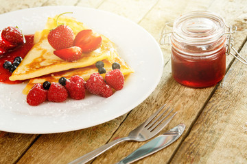 Pancakes with berries and sugar powder