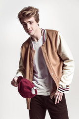 Young fashionable and Handsome man poses at white background in fancy clothes