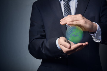 businessman in a suit holding planet earth. Planet earth in the hands. Protect the planet earth.