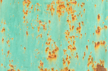 background rusty metal on green paint with cracks in the structure