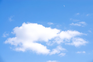 white cloud and the moon crescent on a background of blue sky in early spring in Ukraine