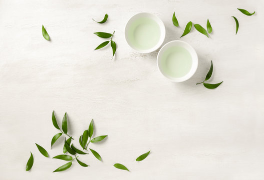 Two white cups of tea, view from above background