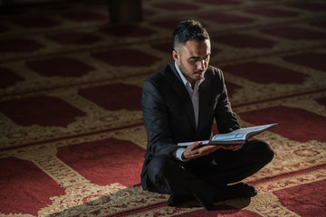 Fototapeta premium Elegant business man studying holy book Koran