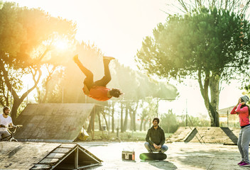 Breakdancer permorming a stunt jump in skate park outdoor