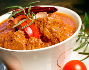 Stew - beef goulash in white bowl on table close-up