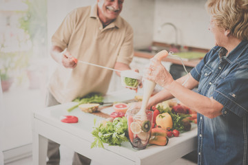 Senior couple cooking healthy vegan meal with fruits and vegetables together