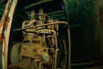 machinery in an underwater shipwreck is now home to a variety of marine life. fish live in the parts of the vessel that was deliberately sunk to create an artificial reef and habitat