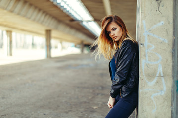 Beautiful young woman posing in a black leather jacket