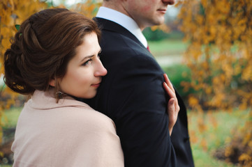 Fototapeta premium Romantic embrace of newlyweds. Couple walks in the park.