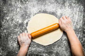 Dough background. The rolling of the hands of women for cookies.