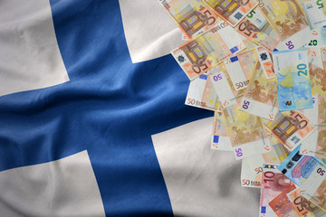 euro money banknotes on the waving national flag of finland.