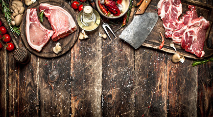 Raw meat background. Raw pork chop with a variety of herbs and spices.