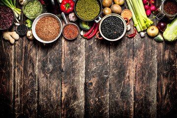 Organic Food. A variety of beans with fresh vegetables and spices. On the old wooden table.