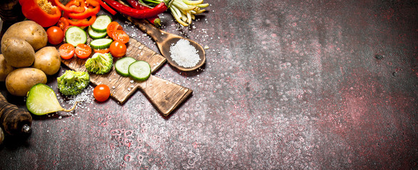Organic Food. Sliced fresh vegetables on the old Board. On rustic background.