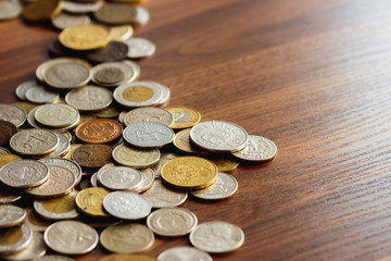 Different gold and silver collector's coins on the wooden table