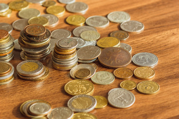 Different gold and silver collector's coins on the wooden table