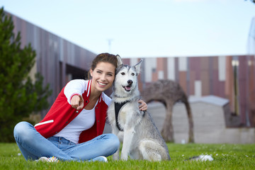 Naklejka na ściany i meble Woman playing with her dog outdoors