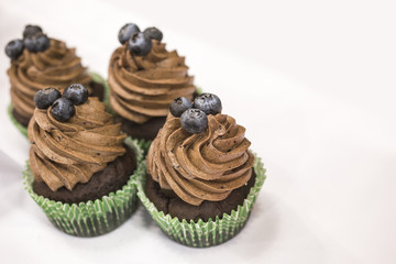 Delicious chocolate cupcakes with buttercream and fruits