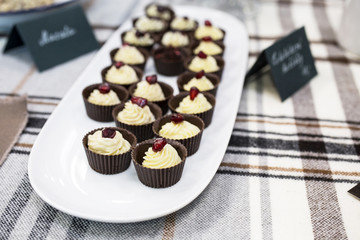 Delicious cupcakes with buttercream and fruits