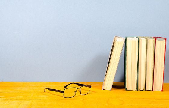 Several Books And Glasses On A Wooden Surface