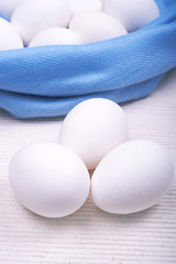 white raw uncooked eggs with a blue and white background 
