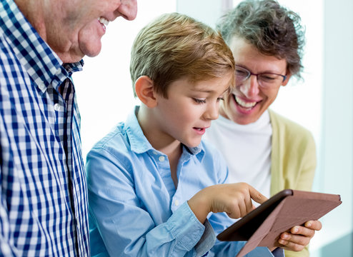 Modern Child With Tablet Asking Grandparents