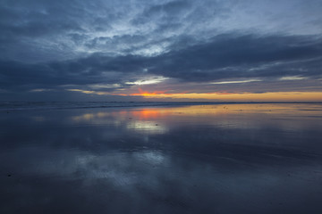 Fototapeta na wymiar Early sunrise over secluded beach in Northumberland, England, UK.