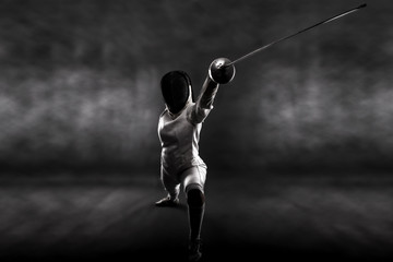 Portrait of woman wearing white fencing costume practicing with the sword.