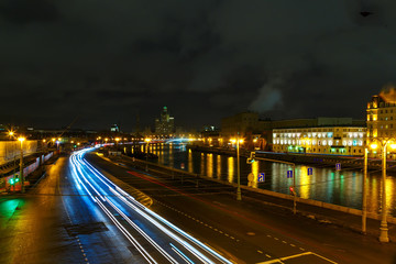 embankment of the Moscow night, the darkness with trails of light from cars.