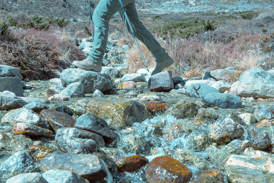 Clean Mountain Creek and Hiker crossing it trendy toned