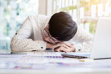  tired businessman sleeping while calculating expenses at desk in office