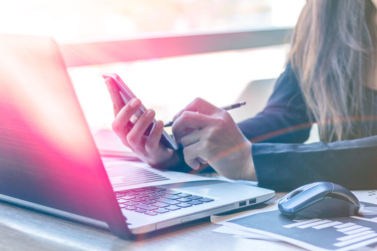 Close Up businessmen working at a coffee shop with a document with a smartphone and a laptop computer.