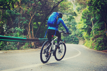 Fototapeta na wymiar young woman riding mountain bike on forest trail