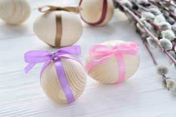 Wooden eggs with colorful tapes with twig of pussy willow on white backround